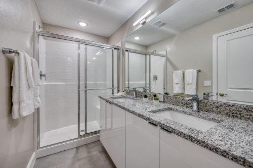 - une salle de bains blanche avec deux lavabos et une douche dans l'établissement Top Villas - Formosa Valley Resort 27, à Orlando