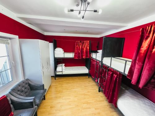 a room with red walls with two bunk beds at Red Apple Hostel in Almaty