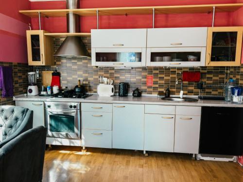 a kitchen with white cabinets and a stove at Red Apple Hostel in Almaty
