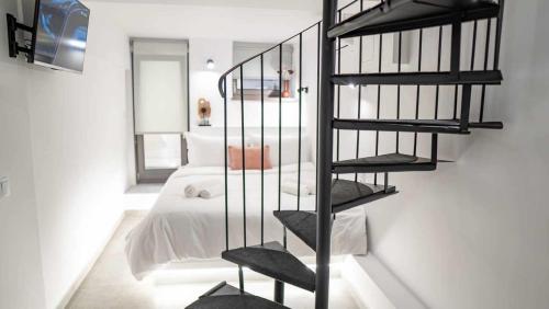 a black spiral staircase in a bedroom with a bed at 1900 Apartments Ioannina in Ioannina