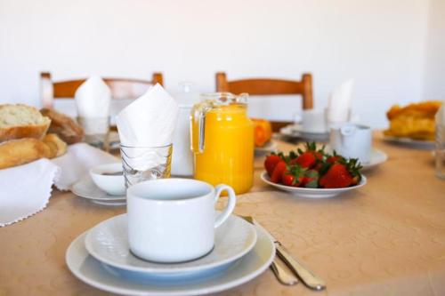 uma mesa com uma chávena de café e uma taça de morangos em 2 bedrooms villa with city view enclosed garden and wifi at Sorthela em Sortelha