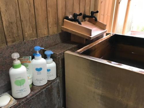 a group of four bottles sitting next to a sink at 金文堂 kinbundo in Himi