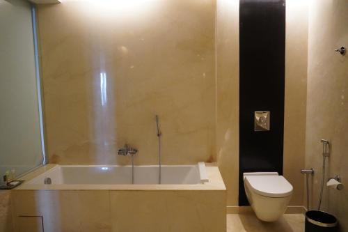 a bathroom with a tub and a toilet at Crowne Plaza Pune City Centre by IHG in Pune