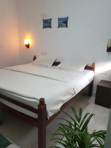 - un lit blanc dans une chambre avec une plante dans l'établissement Greek Villa Baga beach with Private pool & Kitchen CW101, à Baga