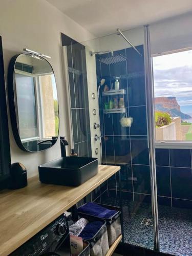 une salle de bain avec un lavabo noir et un miroir dans l'établissement APPARTEMENT VUE SPLENDIDE CASSIS-CLASSE 3 ETOILES, à Cassis