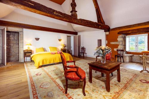Un dormitorio con una cama amarilla y una mesa en Manoir de Kerat en Arradon