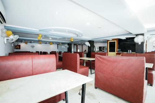 uma sala de jantar com mesas e cadeiras vermelhas em Devdarshan Hotel & Restaurant em Udaipur