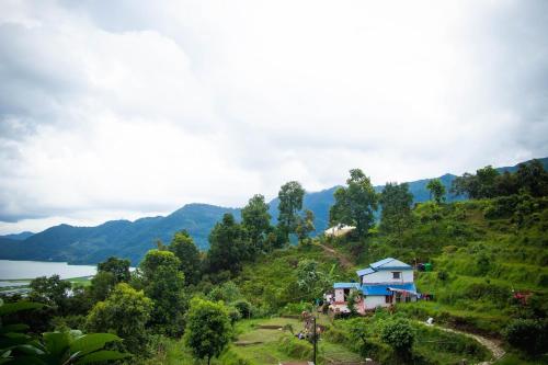 uma casa numa colina ao lado de um lago em Nama Stay Home em Pokhara