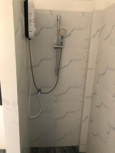 um chuveiro na casa de banho com paredes em mármore em Wild Wood x Hansa Beach Fitness Resort em Thongsala