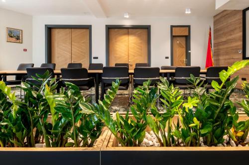 a conference room with chairs and a table and plants at Dve Kule Resort & Winery in Bačinci