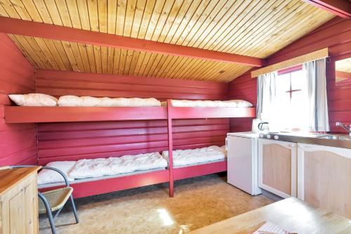 a room with two bunk beds in a red room at Skottevik Feriesenter in Skottevik