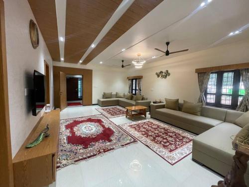 a large living room with a couch and a tv at Coffee minas estate bungalow in Yercaud