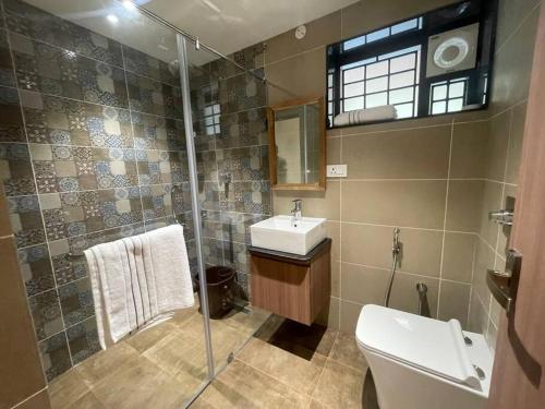 a bathroom with a sink and a shower and a toilet at Coffee minas estate bungalow in Yercaud