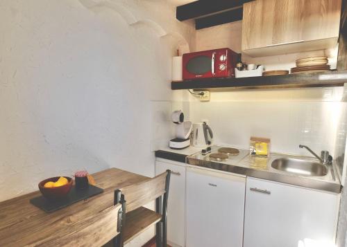 a small kitchen with a sink and a microwave at Torre Costa Brava in Garrigás