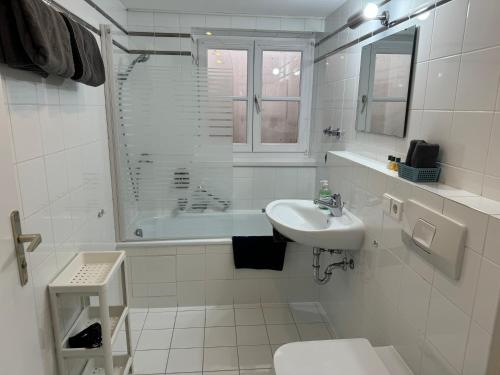 a bathroom with a sink and a toilet and a tub at Ferienwohnung Kity mit Terrasse und Bergblick in Grainau