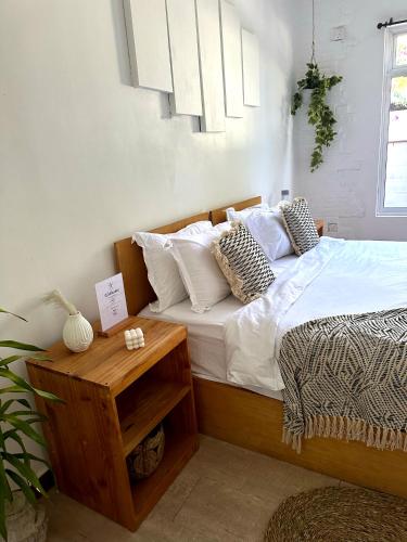 a bedroom with a bed with white sheets and pillows at TWIN PALMS 'Surfhouse' in Thulusdhoo
