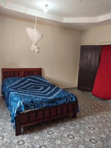 a bedroom with a bed with a blue comforter at Sunshine Guesthouse Bafuloto 