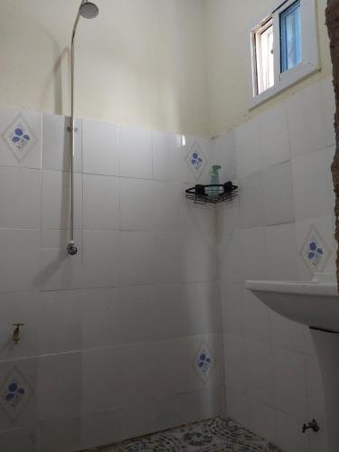 a white bathroom with a shower and a sink at Sunshine Guesthouse Bafuloto 
