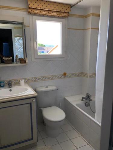 une salle de bain avec toilettes, baignoire et lavabo dans l'établissement Villa la Provençale, à Roquebrune-sur Argens