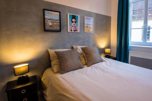 une chambre avec un lit blanc avec deux oreillers dans l'établissement Hesdin Appart Holidays 3, à Hesdin