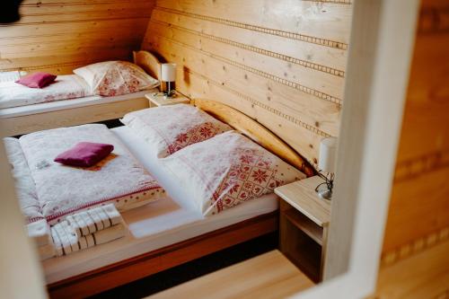 two beds in a small room with a table at SOVA Hotel&Restaurant in Ždiar