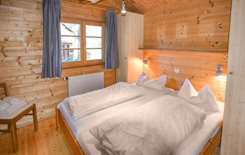 a bedroom with a white bed in a wooden room at Ferienhaus Donau 102 in Hayingen
