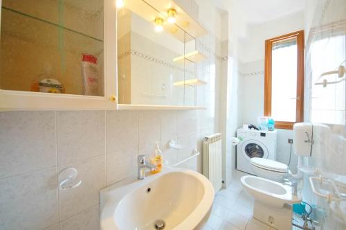 y baño con lavabo y lavadora. en DolceVita Apartments N 518 Giudecca, en Venecia