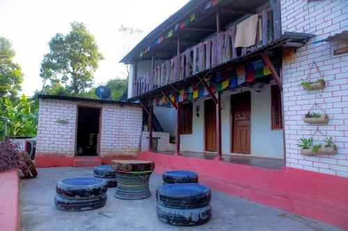 um grupo de bancos em frente a um edifício em NAMA STAY HOME em Pokhara