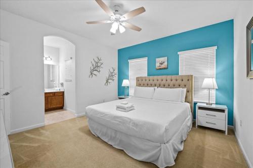 um quarto com uma cama branca e uma parede azul em Top Villas - Solterra Resort 816 em Davenport
