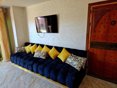 ein blaues Sofa mit gelben Kissen in einem Zimmer in der Unterkunft Luxueux appartement à Sahara beach mohammedia in Mansouria