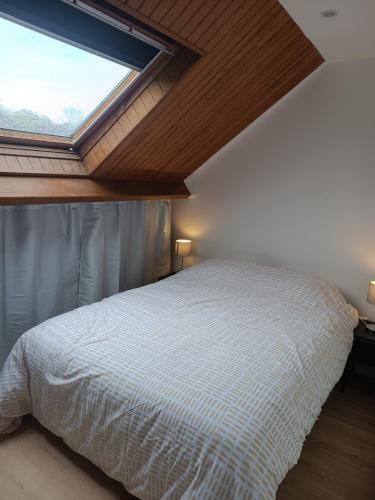 une chambre avec un lit avec une grande fenêtre dans l'établissement logement cosy et au calme proche Paris Aéroport CDG DISNEY ASTERIX, à Fontenay-en-Parisis