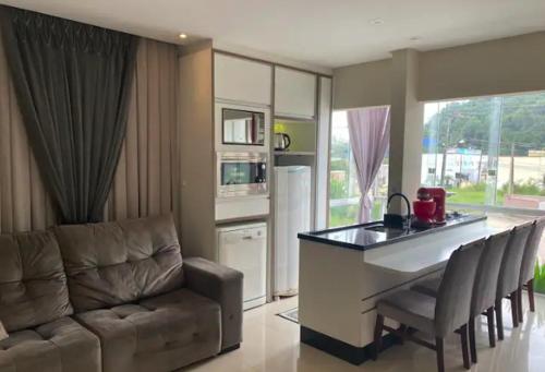 uma sala de estar com um sofá e uma cozinha em Apto - 30 min de BC em Brusque