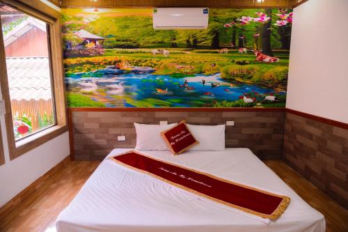 a bed in a room with a painting on the wall at Trang An Hometown Homestay in Ninh Binh