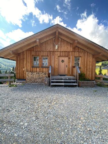 a log cabin with a staircase leading to the front door at Jagdhütte in Lachtal