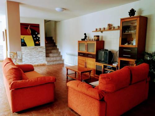 a living room with two couches and a tv at Casa de campo tranquila en vilar cerca de santiago in Touro