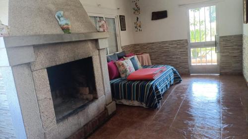 sala de estar con chimenea y sofá en Casa de campo tranquila en vilar cerca de santiago, en Touro