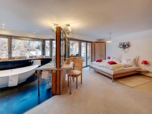 um quarto com uma cama, uma banheira e um lavatório em Backstage Hotel Serviced Apartments em Zermatt