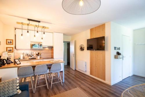 une cuisine avec une table et des chaises dans une pièce dans l'établissement Comfortable apartment with pool, à Moliets-et-Maa