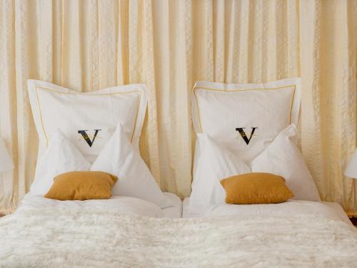 a white bed with two pillows on top of it at Backstage Hotel Serviced Apartments in Zermatt