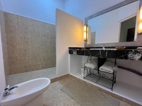 bagno con lavandino e specchio di Hotel L'Oliveraie Jnane Zitoune a Marrakech