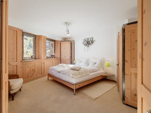 a bedroom with a bed and a chair in it at Backstage Hotel Serviced Apartments in Zermatt
