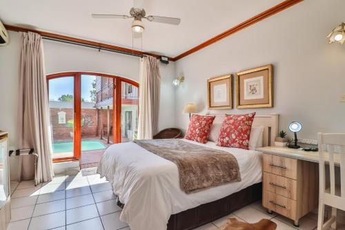 een slaapkamer met een groot bed en een raam bij Cascade Villa Guesthouse in Secunda