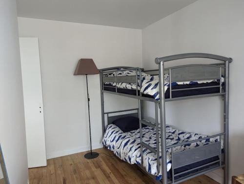 une chambre avec deux lits superposés et une lampe dans l'établissement Appartement face à la plage du val André, à Pléneuf-Val-André