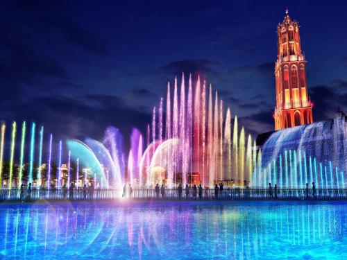 a fountain in front of a building with a clock tower at Hotel Denhaag Huis Ten Bosch in Sasebo