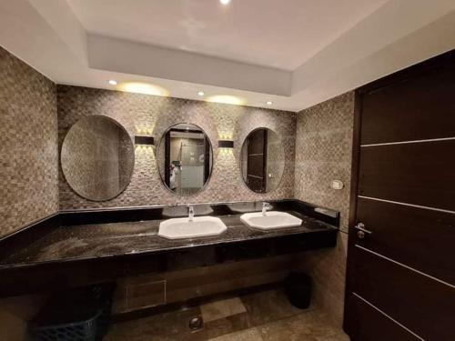 a bathroom with two sinks and two mirrors at Welcome home in Ma‘ān