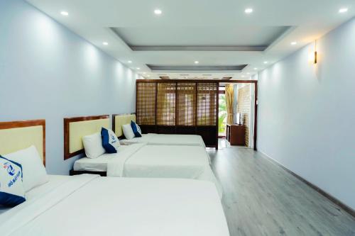 um quarto de hotel com duas camas e um sofá em HỒ MÂY PARK Vũng Tàu Khách Sạn - Resort em Vung Tau