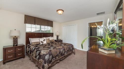 een slaapkamer met een bed, een dressoir en een raam bij Top Villas - Paradise Palms Resort 280 in Kissimmee