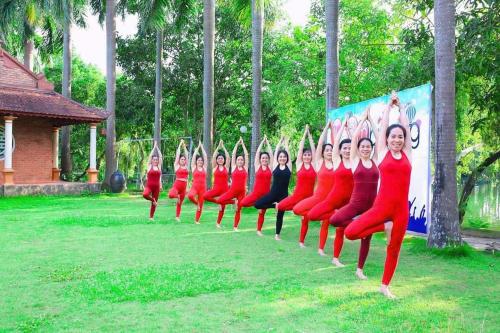 a group of women in red uniforms doing yoga at Mango room2 in Xóm Chua Thanh