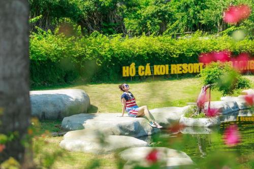 a young child sitting on some rocks near a pond at Mango room2 in Xóm Chua Thanh