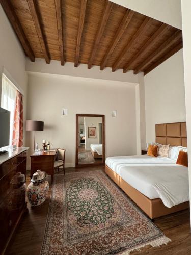 a bedroom with a bed and a desk and a television at Residenza Palazzo Fortuna - Boutique Hotel in Civita Castellana